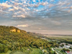 Landscape shot of a series of hills overlooking a rural township in the bottom corner.